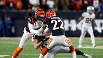 CINCINNATI, OHIO - JANUARY 15: Eli Apple #20 and Chidobe Awuzie #22 of the Cincinnati Bengals tackle Hunter Renfrow #13 of the Las Vegas Raiders during the second half of the AFC Wild Card playoff game at Paul Brown Stadium on January 15, 2022 in Cincinnati, Ohio. (Photo by Dylan Buell/Getty Images)