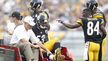 Sep 8, 2013; Pittsburgh, PA, USA; Pittsburgh Steelers center Maurkice Pouncey (53) is taken from the field after suffering an apparent injury as wide receiver Antonio Brown (84) reacts against the Tennessee Titans during the first quarter at Heinz Field. Mandatory Credit: Charles LeClaire-USA TODAY Sports