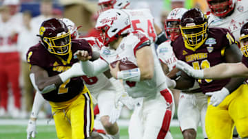 DETROIT, MI - DECEMBER 7: Defensive linemen Sean Adesanya #2 and Mohamed Diallo #70 of the Central Michigan Chippewas pursues quarterback Brett Gabbert #5 of the Miami (Oh) Redhawks during the second half of the MAC Championship at Ford Field on December 7, 2019, in Detroit, Michigan. (Photo by Duane Burleson/Getty Images)