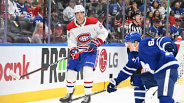 Oct 2, 2023; Toronto, Ontario, CAN; Montreal Canadiens defenseman Logan Mailloux (94) clears the puck past Toronto Maple Leafs forward David Kampf (64) in the first period at Scotiabank Arena. Mandatory Credit: Dan Hamilton-USA TODAY Sports