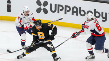 Mar 5, 2021; Boston, Massachusetts, USA; Washington Capitals left wing Carl Hagelin (62) battles for the puck against Boston Bruins center Craig Smith (12) during the second period at TD Garden. Mandatory Credit: Paul Rutherford-USA TODAY Sports
