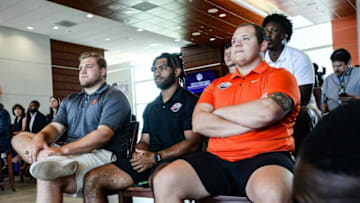 Clemson football players, from left, offensive guard Matt Bockhorst, Darien Rencher, Zac McIntosh, and K.J. Henry listen to South Carolina Gov. Henry McMaster speaks during a press conference and s. 685, Compensation of Intercollegiate Athletes, a ceremonial bill-signing at Memorial Stadium in Clemson Monday, June 14, 2021.Compensation Of Intercollegiate Athletes