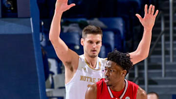 Jan 28, 2023; South Bend, Indiana, USA; Louisville Cardinals forward Emmanuel Okorafor (34) controls the ball against Notre Dame Fighting Irish forward Nate Laszewski (14) in the second half at the Purcell Pavilion. Mandatory Credit: Matt Cashore-USA TODAY Sports