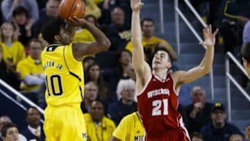 Jan 24, 2015; Ann Arbor, MI, USA; Michigan Wolverines guard Derrick Walton Jr. (10) shoots a three point shot on Wisconsin Badgers guard Josh Gasser (21) in the second half at Crisler Center. Wisconsin won 69-64 in overtime. Mandatory Credit: Rick Osentoski-USA TODAY Sports