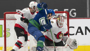 VANCOUVER, BC - APRIL 22: Matthew Highmore #15 of the Vancouver Canucks tries to get his stick on the loose puck after goalie Matt Murray #30 of the Ottawa Senators made a pad save during the third period of NHL action at Rogers Arena on April 22, 2021 in Vancouver, Canada. Erik Brannstrom #26 of the Ottawa Senators helps defend on the play. (Photo by Rich Lam/Getty Images)