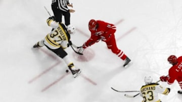 Feb 26, 2016; Raleigh, NC, USA; Boston Bruins forward Patrice Bergeron (37) and Carolina Hurricanes forward Elias Lindholm (16) face off at PNC Arena. The Boston Bruins defeated the Carolina Hurricanes 4-1. Mandatory Credit: James Guillory-USA TODAY Sports