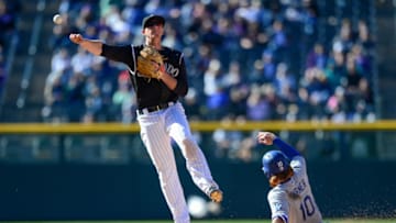 DENVER, CO - APRIL 9: DJ LeMahieu #9 of the Colorado Rockies throws to first base to complete a double play after forcing out Justin Turner #10 of the Los Angeles Dodgers in the eighth inning of a game at Coors Field on April 9, 2017 in Denver, Colorado. (Photo by Dustin Bradford/Getty Images)