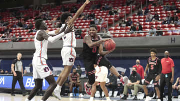 Auburn basketballFeb 2, 2021; Auburn, Alabama, USA; Georgia Bulldogs guard K.D. Johnson (0) makes a pass around Auburn Tigers guard Sharife Cooper (2) and forward JT Thor (10) during the second half at Auburn Arena. Mandatory Credit: John Reed-USA TODAY Sports