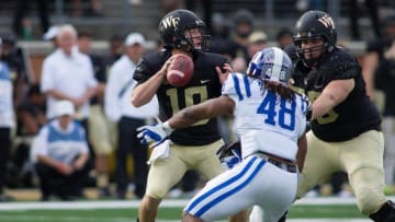Nov 28, 2015; Winston-Salem, NC, USA; Wake Forest Demon Deacons quarterback John Wolford (10) looks to pass the ball while Duke Blue Devils defensive end Deion Williams (48) applies pressure during the third quarter at BB&T Field. Duke defeated Wake Forest 27-21. Mandatory Credit: Jeremy Brevard-USA TODAY Sports