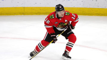 CHICAGO, ILLINOIS - FEBRUARY 25: Alex DeBrincat #12 of the Chicago Blackhawks controls the puck during a game against the New Jersey Devils at United Center on February 25, 2022 in Chicago, Illinois. (Photo by Stacy Revere/Getty Images)