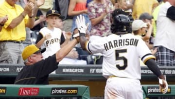 Jul 6, 2014; Pittsburgh, PA, USA; Pittsburgh Pirates manager Clint Hurdle (L) greets Pittsburgh Pirates left fielder Josh Harrison (5) at the dugout after Harrison scored a run against the Philadelphia Phillies during the eighth inning at PNC Park. The Pirates won 6-2. Mandatory Credit: Charles LeClaire-USA TODAY Sports