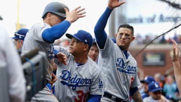 SAN FRANCISCO, CA - SEPTEMBER 29: Enrique Hernandez #14 of the Los Angeles Dodgers is congratulated by manager Dave Roberts #30 and teammate Manny Machado #8 after scoring on single hit by Chris Taylor #3 of the Los Angeles Dodgers during the ninth inning against the San Francisco Giants at AT&T Park on September 29, 2018 in San Francisco, California. (Photo by Lachlan Cunningham/Getty Images)