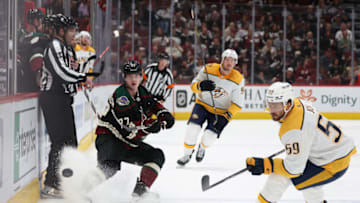 GLENDALE, ARIZONA - APRIL 29: Victor Soderstrom #77 of the Arizona Coyotes dumps the puck past Roman Josi #59 of the Nashville Predators during the second period of the NHL game at Gila River Arena on April 29, 2022 in Glendale, Arizona. (Photo by Christian Petersen/Getty Images)