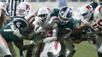 EAST LANSING, MI - NOVEMBER 24: Running back Jonathan Hilliman #23 of the Rutgers Scarlet Knights is tackled by defensive tackle Raequan Williams #99 of the Michigan State Spartans and linebacker Tyriq Thompson #17 of the Michigan State Spartans during the second half at Spartan Stadium on November 24, 2018 in East Lansing, Michigan. Michigan State defeated Rutgers 14-10. (Photo by Duane Burleson/Getty Images)