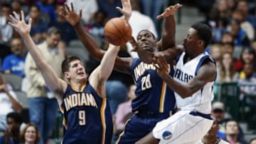 Oct 12, 2014; Dallas, TX, USA; Dallas Mavericks forward Al-Farouq Aminu (7) passes as Indiana Pacers forward Damjan Rudez (9) and center Ian Mahinmi (28) defend during the second half at American Airlines Center. Mandatory Credit: Kevin Jairaj-USA TODAY Sports