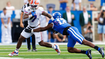 Sep 30, 2023; Lexington, Kentucky, USA; Florida Gators running back Trevor Etienne (7) runs the ball against Kentucky Wildcats linebacker J.J. Weaver (13) during the fourth quarter at Kroger Field. Mandatory Credit: Jordan Prather-USA TODAY Sports