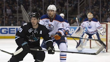 Mar 24, 2016; San Jose, CA, USA; San Jose Sharks center Logan Couture (39) and Edmonton Oilers defenseman Griffin Reinhart (8) look up the ice as Oilers goalie Cam Talbot (33) defends the goal in the third period at SAP Center at San Jose. Mandatory Credit: Kenny Karst-USA TODAY Sports