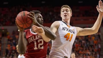 Jan 13, 2016; Stillwater, OK, USA; Oklahoma Sooners forward Khadeem Lattin (12) fights for position as Oklahoma State Cowboys forward Mitchell Solomon (41) defends during the first half at Gallagher-Iba Arena. OU won 74-72. Mandatory Credit: Rob Ferguson-USA TODAY Sports