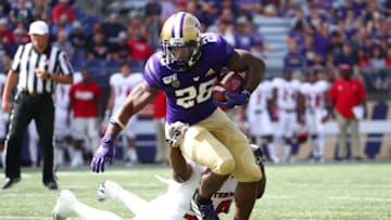 SEATTLE, WASHINGTON - AUGUST 31: Salvon Ahmed #26 of the Washington Huskies is tackled by Chris Ojoh #58 of the Eastern Washington Eagles in the first quarter during their game at Husky Stadium on August 31, 2019 in Seattle, Washington. (Photo by Abbie Parr/Getty Images)