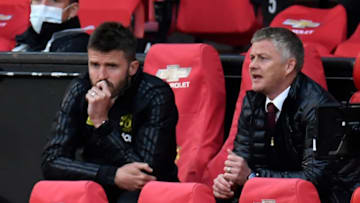 Manchester United's Norwegian manager Ole Gunnar Solskjaer (R) and Manchester United's English first-team coach Michael Carrick (L) watch from their seats in the stands during the English Premier League football match between Manchester United and Southampton at Old Trafford in Manchester, north-west England, on July 13, 2020. (Photo by PETER POWELL / POOL / AFP) / RESTRICTED TO EDITORIAL USE. No use with unauthorized audio, video, data, fixture lists, club/league logos or 'live' services. Online in-match use limited to 120 images. An additional 40 images may be used in extra time. No video emulation. Social media in-match use limited to 120 images. An additional 40 images may be used in extra time. No use in betting publications, games or single club/league/player publications. / (Photo by PETER POWELL/POOL/AFP via Getty Images)