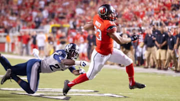 Sep 11, 2015; Salt Lake City, UT, USA; Utah Utes running back Devontae Booker (23) evades the tackle of Utah State Aggies safety Jontrell Rocquemore (27) as he runs for a touchdown during the first half at Rice-Eccles Stadium. Mandatory Credit: Russ Isabella-USA TODAY Sports