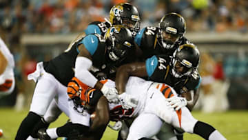 Aug 28, 2016; Jacksonville, FL, USA; Cincinnati Bengals running back Tra Carson (39) is tackled by Jacksonville Jaguars linebacker Sean Porter (53) along with linebacker Myles Jack (44) and nose tackle Richard Ash (94) and defensive tackle Tyson Alualu (93) in the third quarter at EverBank Field. The Jacksonville Jaguars won 26-21. Mandatory Credit: Logan Bowles-USA TODAY Sports
