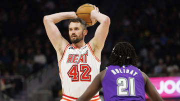 Feb 24, 2023; Milwaukee, Wisconsin, USA; Miami Heat forward Kevin Love (42) looks to pass the ball away from Milwaukee Bucks guard Jrue Holiday (21) during the third quarter at Fiserv Forum. Mandatory Credit: Jeff Hanisch-USA TODAY Sports