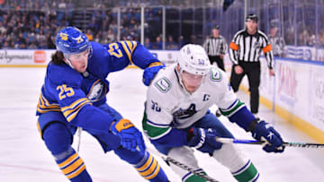 Nov 15, 2022; Buffalo, New York, USA; Vancouver Canucks center Bo Horvat (53) and Buffalo Sabres defenseman Owen Power (25) battle for the puck in the first period at KeyBank Center. Mandatory Credit: Mark Konezny-USA TODAY Sports