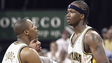 INDIANAPOLIS - APRIL 17: Jermaine O'Neal #7 of the Indiana Pacers is restrained by teammate Fred Jones #20 and referee Bennett Salvatore against the Boston Celtics on April 17, 2004 at the Conseco Fieldhouse in Indianapolis, Indiana. The Pacers beat the Celtics 104-88. O'Neal and Brandon hunter of the Boston Celtics had tangeled with each other. (Photo by Dilip Vishwanat/Getty Images)