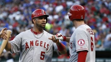 Jul 12, 2014; Arlington, TX, USA; Los Angeles Angels first baseman Albert Pujols (5) is congratulated after scoring by third baseman David Freese (6) against the Texas Rangers during the sixth inning of a baseball game at Globe Life Park in Arlington. Mandatory Credit: Jim Cowsert-USA TODAY Sports