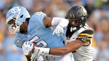 CHAPEL HILL, NORTH CAROLINA - SEPTEMBER 21: Kaiden Smith #13 of the Appalachian State Mountaineers tackles Dazz Newsome #5 of the North Carolina Tar Heels during the second half of their game at Kenan Stadium on September 21, 2019 in Chapel Hill, North Carolina. The Mountaineers won 34-31. (Photo by Grant Halverson/Getty Images)