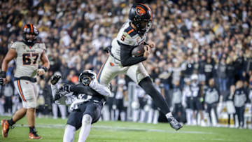 Nov 4, 2023; Boulder, Colorado, USA; Oregon State Beavers quarterback DJ Uiagalelei (5) leaps past Colorado Buffaloes safety Shilo Sanders (21) at Folsom Field. Mandatory Credit: Chet Strange-USA TODAY Sports