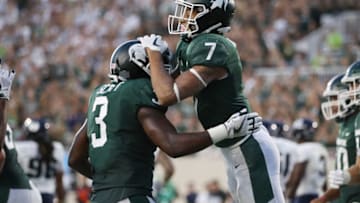 EAST LANSING, MI - AUGUST 31: Cody White #7 of the Michigan State Spartans celebrates his first half touchdown with LJ Scott #3 while playing the Utah State Aggies at Spartan Stadium on August 31, 2018 in East Lansing, Michigan. (Photo by Gregory Shamus/Getty Images)