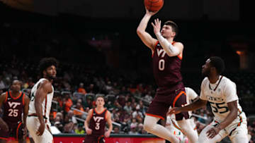 Jan 31, 2023; Coral Gables, Florida, USA; Virginia Tech Hokies guard Hunter Cattoor (0) puts up a shot over Miami Hurricanes guard Wooga Poplar (55) during the first half at Watsco Center. Mandatory Credit: Jasen Vinlove-USA TODAY Sports