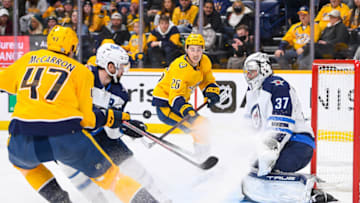 Jan 20, 2022; Nashville, Tennessee, USA; Winnipeg Jets goaltender Connor Hellebuyck (37) blocks the shot of Nashville Predators center Philip Tomasino (26) during the third period at Bridgestone Arena. Mandatory Credit: Steve Roberts-USA TODAY Sports