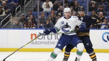 BUFFALO, NY - JANUARY 11: Tanner Pearson #70 of the Vancouver Canucks and Brandon Montour #62 of the Buffalo Sabres battle for position in front of the Buffalo net during the third period of play in the NHL hockey game between the Vancouver Canucks and Buffalo Sabres at KeyBank Center on January 11, 2020 in Buffalo, New York. (Photo by Nicholas T. LoVerde/Getty Images)