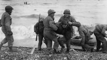 American troops helping their injured friends from a dinghy after the landing ship they were on was hit by enemy fire during the Allied invasion of France on D-Day