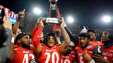 Cincinnati Bearcats linebacker Deshawn Pace raises trophy. The Enquirer.