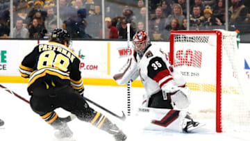 BOSTON, MA - DECEMBER 11: Arizona Coyotes goalie Darcy Kuemper (35) keeps tabs on the puck with Boston Bruins right wing David Pastrnak (88) crashing the net during a game between the Boston Bruins and the Arizona Coyotes on December 11, 2018, at TD Garden in Boston, Massachusetts. (Photo by Fred Kfoury III/Icon Sportswire via Getty Images)
