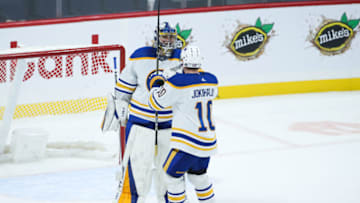 Jan 26, 2023; Winnipeg, Manitoba, CAN; Buffalo Sabres goalie Eric Comrie (31) is congratulated by Buffalo Sabres defenseman Henri Jokiharju (10) on his win against the Winnipeg Jets at the end of the third period at Canada Life Centre. Mandatory Credit: Terrence Lee-USA TODAY Sports