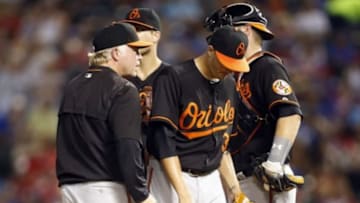 Aug 28, 2015; Arlington, TX, USA; Baltimore Orioles starting pitcher Kevin Gausman (39) leaves the mound after giving the ball to manager Buck Showalter (26) in the seventh inning against the Texas Rangers at Globe Life Park in Arlington. Texas won 4-1. Mandatory Credit: Tim Heitman-USA TODAY Sports