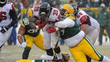 Dec 8, 2013; Green Bay, WI, USA; Atlanta Falcons running back Steven Jackson (39) is tackled by Green Bay Packers defensive tackle Ryan Pickett (79) and cornerback Tramon Williams (38) in the 4th quarter at Lambeau Field. Mandatory Credit: Benny Sieu-USA TODAY Sports