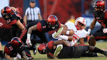 SAN DIEGO, CA - NOVEMBER 24: Trey Lomax #3, Parker Baldwin #33 and Tariq Thompson #14 of the San Diego State Aztecs tackle Tevaka Tuioti #16 of the New Mexico Lobos during the second half of a game at Qualcomm Stadium on November 24, 2017 in San Diego, California. (Photo by Sean M. Haffey/Getty Images)