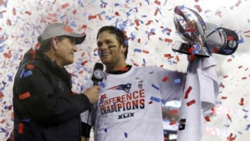 Jan 18, 2015; Foxborough, MA, USA; New England Patriots quarterback Tom Brady (right) holds up the Lamar Hunt Trophy as he is interviewed after the AFC Championship Game against the Indianapolis Colts at Gillette Stadium. Mandatory Credit: David Butler II-USA TODAY Sports