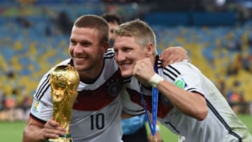 RIO DE JANEIRO, BRAZIL - JULY 13: Lukas Podolski and Bastian Schweinsteiger of Germany pose with the World Cup trophy after defeating Argentina 1-0 in extra time during the 2014 FIFA World Cup Brazil Final match between Germany and Argentina at Maracana on July 13, 2014 in Rio de Janeiro, Brazil. (Photo by Matthias Hangst/Getty Images)