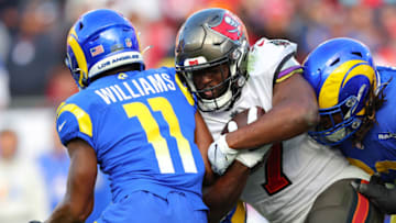 TAMPA, FLORIDA - JANUARY 23: Leonard Fournette #7 of the Tampa Bay Buccaneers runs with the ball as Darious Williams #11 of the Los Angeles Rams defends in the third quarter in the NFC Divisional Playoff game at Raymond James Stadium on January 23, 2022 in Tampa, Florida. (Photo by Kevin C. Cox/Getty Images)