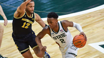 EAST LANSING, MICHIGAN - JANUARY 29: Tyson Walker #2 of the Michigan State Spartans attempts to drive past DeVante' Jones #12 of the Michigan Wolverines during the first half of a college basketball game at Breslin Center on January 29, 2022 in East Lansing, Michigan. (Photo by Aaron J. Thornton/Getty Images)
