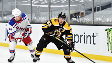 Mar 11, 2021; Boston, Massachusetts, USA; Boston Bruins center Brad Marchand (63) controls the puck against New York Rangers defenseman Adam Fox (23) during the third period at TD Garden. Mandatory Credit: Bob DeChiara-USA TODAY Sports