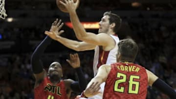 Jan 31, 2016; Miami, FL, USA; Miami Heat guard Goran Dragic (7) scores between Atlanta Hawks forward Paul Millsap (4) and guard Kyle Korver (26) during the first half at American Airlines Arena. Mandatory Credit: Steve Mitchell-USA TODAY Sports