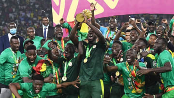 Senegal's players celebrate with the trophy after winning the Africa Cup of Nations (CAN) 2021 final football match between Senegal and Egypt at Stade d'Olembe in Yaounde on February 6, 2022. (Photo by CHARLY TRIBALLEAU / AFP) (Photo by CHARLY TRIBALLEAU/AFP via Getty Images)